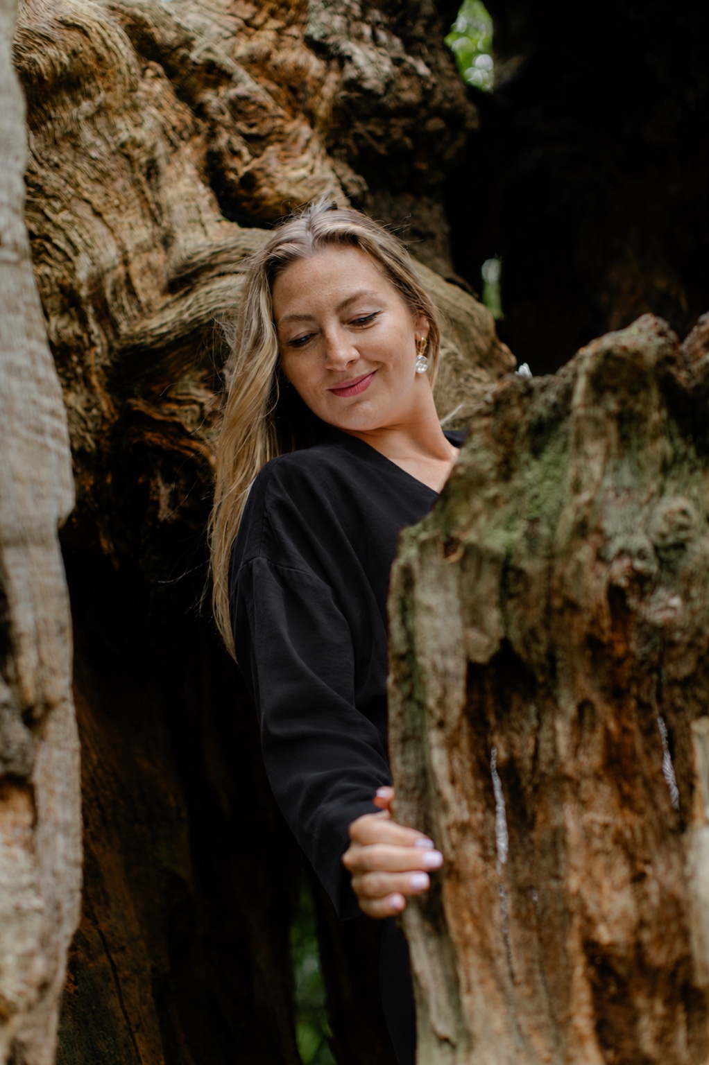 Linda standing among the folds of an ancient tree